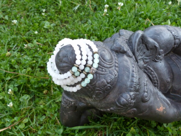 Ganesh allongé sur lit d'herbe paré d'un Mala Intentionnel fait main de quartz rose et Jade